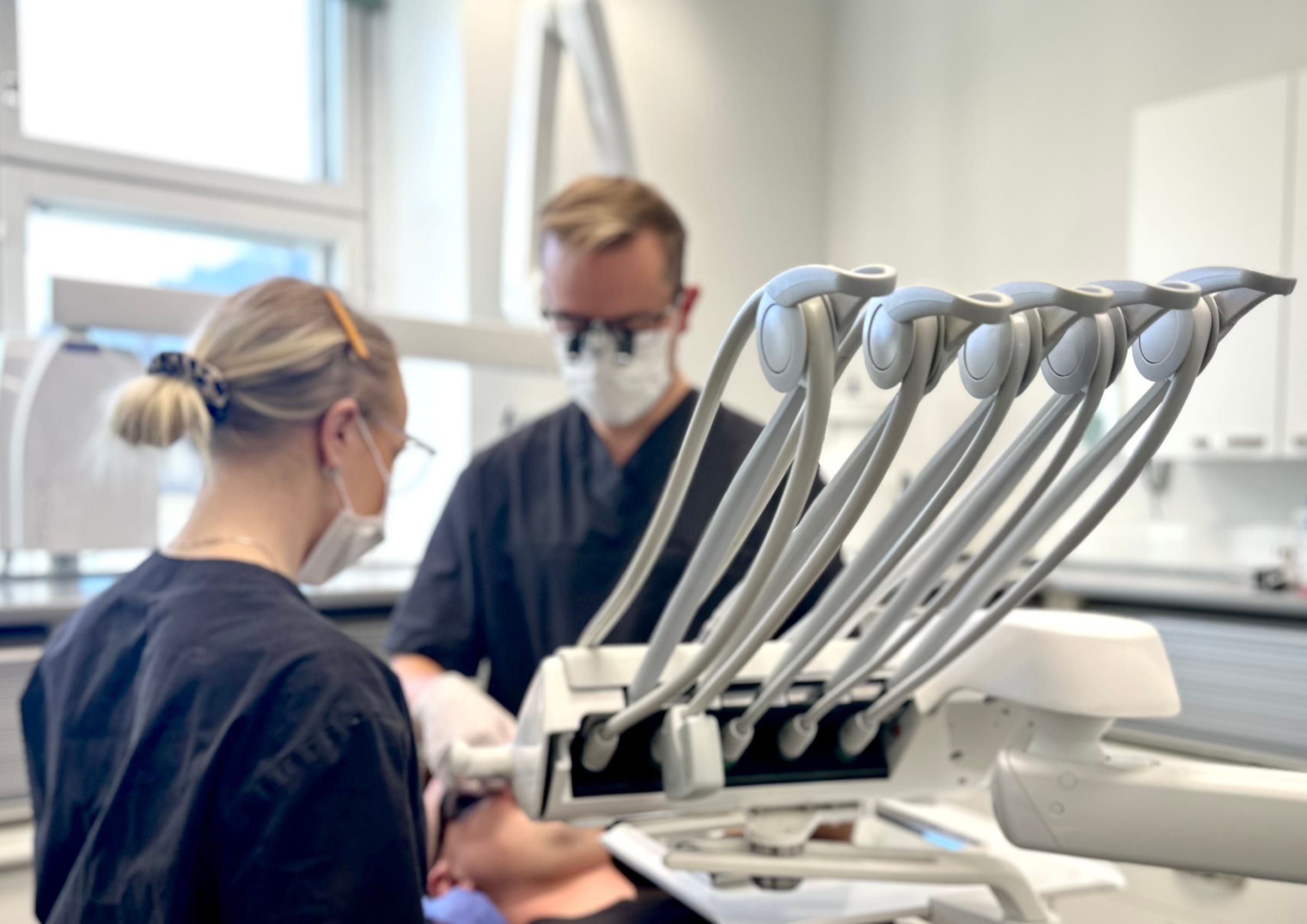 Dentrumin hoitohenkilökunta hoitaa potilasta hoitohuoneessa Tampereella, etualalla hoitoyksikön instrumentit